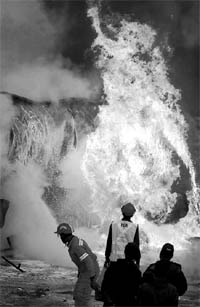Firefighters try to douse flames emanating from an oil tanker carrying fuel supplies for NATO forces in Afghanistan. The tanker was attacked by militants on the outskirt of Peshawar on Saturday
