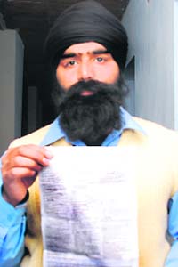 Harwinder Singh shows the challan receipt while sporting the same turban, which he was wearing at the time the challan