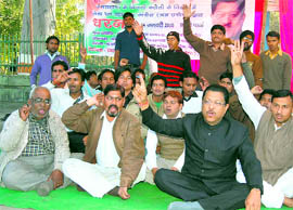 Congress workers protest against power shortage in the state at the Gandhi Park in Dehradun on Sunday