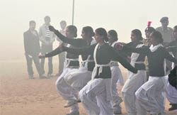 Youths (in the background) engage in eve-teasing as girl cadets rehearse for the Republic Day parade in Ludhiana