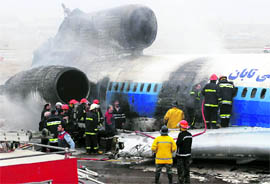 Iranian firefighters work on a plane after it crash-landed at Mashhad airport in northeastern Iran on Sunday. The Tupolev plane carrying 157 passengers 