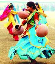 A girl dances carrying three pitchers during the rehearsals for the Republic Day function in Amritsar.