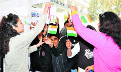 National flags being given to students at a fete at Summer Valley School in Dehradun on Sunday