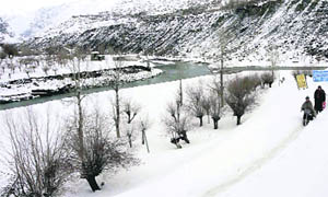 People walking through a snow-laden path at Keylong in Himachal Pradesh on Sunday.
