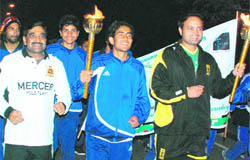 Cricketer Dinesh Mongia holds the Chandigarh Marathon torch near Rock Garden on Wednesday.