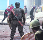 Youths pelt security personnel with stones during a protest at Batmaloo in Srinagar