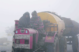 This tractor driver drives slow in dense fog near Taraouri in Karnal. 