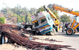 The traffic police clears the road at Panama Chowk in Jammu after a truck overturned there on Thursday