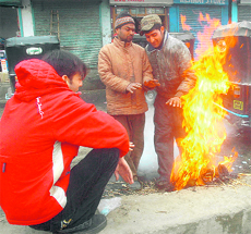 These boys try to get some warmth near a roadside bonfire in Srinagar.