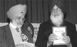 Punjab Chief Minister Parkash Singh Badal and Federation of Senior Citizens Association president AS Khera launch a souvenir of the federation in Mohali 