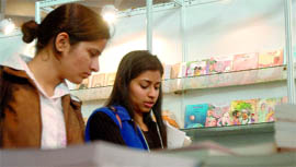 Girls check out books at the fair.