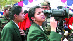 A girl student has a feel of night watch instrument used by the Army at an exhibition in Pathankot
