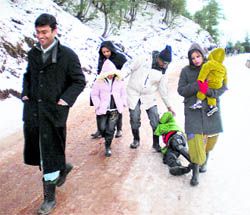 Tourists enjoy snowfall at Nathatop in the Jammu region on Saturday