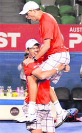 Mike Bryan jumps on brother Bob Bryan after they defeated Daniel Nestor and Nenad Zimonjic in the men's doubles final at the Australian Open in Melbourne on Saturday.