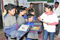 Members of Janani Ritej distribute blankets and books among children of Rajkiya Vidyalaya.