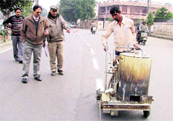 Officials monitor the road-marking work in Ludhiana