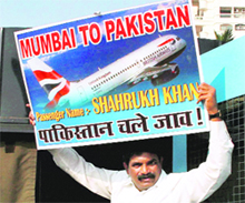 A Shiv Sena activist shows a placard depicting an air ticket to Shah Rukh Khan during a protest outside his residence in Mumbai on Sunday after the actor spoke in favour of Pakistani players in IPL-3. 