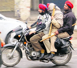 Three policemen ride a motorcycle in Amritsar on Sunday