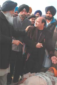 Punjab Chief Minister Parkash Singh Badal enquiring about the well-being of an old man at the Enna Khera village during a Sangat Darshan in Muktsar district