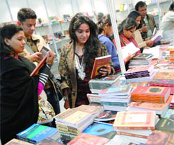 People check out books at a stall during the 19th World Book Fair at Pragati Maidan in New Delhi on Monday.