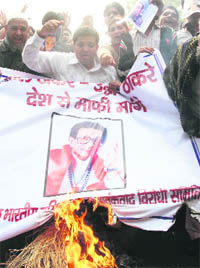 Activists of a pro-Muslim body burn the poster of Shiv Sena supremo Bal Thackeray in New Delhi on Monday.