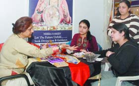 Young girls consult a tarot card reader at the Nakshatra pavilion at the World Book Fair