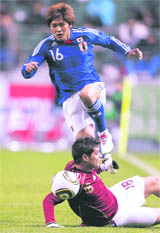 Japans Yoshito Okubo (top) tries to avoid colliding with Venezuelas Giovanny Romero during their Kirin Cup match in Oita, southwestern Japan on Tuesday.