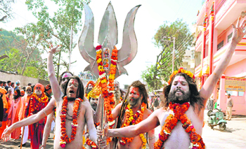 Ash-smeared sadhus carry a trishul