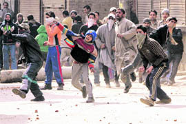 Valley continues to burn: Youths pelt security personnel with stones in Srinagar on Wednesday. The Kashmir valley saw widespread clashes and shutdown against the death of a teenager in tear gas shelling on Sunday. 