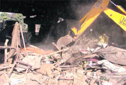 A JCB machine demolishes illegal structures at Cheema Chowk in Ludhiana on Wednesday.