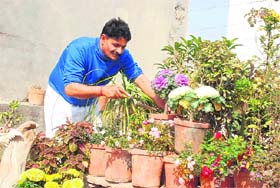 Handball coach Rakesh Solanki tends to flowerpots on the rooftop of his house in Hisar