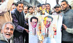 Congress supporters burn posters of Shiv Sena supremo Bal Thackeray in Moradabad