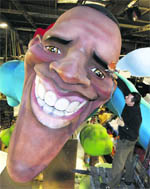 A worker gives final touches on a giant face of US President Barack Obama during preparations for the carnival parade in Nice, southeastern France, on Friday.