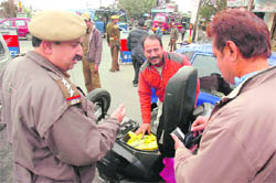 Policemen check vehicles during a search operation in Jammu 