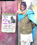 Ram Rattan with the Alcoholics Anonymous (AA) poster outside his tenement in Colony No 4, Chandigarh, on Sunday.