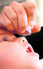 A health worker administers drops to a child during the pulse polio programme in Jammu on Sunday