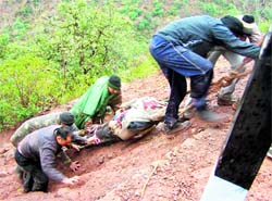 Rescue workers carry a body from a gorge at Jharkhani in Udhampur on Sunday