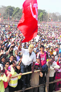 A CPM activist wearing mask of veteran communist leader Jyoti Basu waves a party flag during a Left Front rally in Kolkata on Sunday