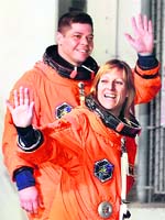 Mission specialists Kay Hire and Bob Behnken walk out of the operations and check-out building at the Kennedy Space Center at Cape Canaveral on Sunday. NASA postponed the launch of the space shuttle because of cloudy skies in Florida