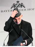 Afghan President Hamid Karzai adjusts his hat before his speech at the 46th Conference on Security Policy 