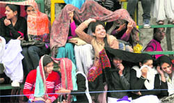 Girls use shawls to protect themselves from rain in Ludhiana on Monday. Tribune photo: Himanshu Mahajan