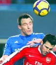John Terry of Chelsea and Cesc Fabregas of Arsenal (front) jump for a header during their Premier League soccer match at Stamford Bridge in London on Sunday