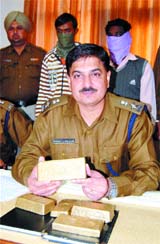 Gurmeet Singh Chouhan, SSP Amritsar rural shows the fake gold bricks.