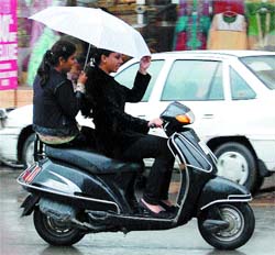 Girls enjoy a ride in rain in Amritsar.