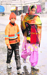A woman and her son walk in the rain.