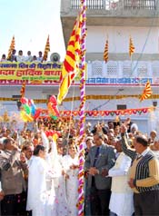 People shower flower petals as DIG BSF Vimal Satyarthi unfurls the Shiva flag at Abohar