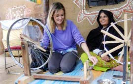 A foreigner tries her hands at a charkha at the Surajkund Crafts Fair in Faridabad.