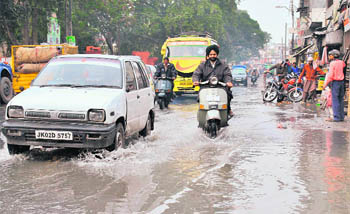 Vehicles ply through a water-logged road in front of Science College in 