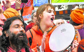 A foreigner sings a religious song along with sadhus while on their way to participate in the first Shahi Snan (Royal Bath) at Mahakumbh in Haridwar