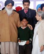 Chief Minister Parkash Singh Badal honouring Gurjeevan Singh with a cheque of Rs 1 lakh in Bathinda on Friday